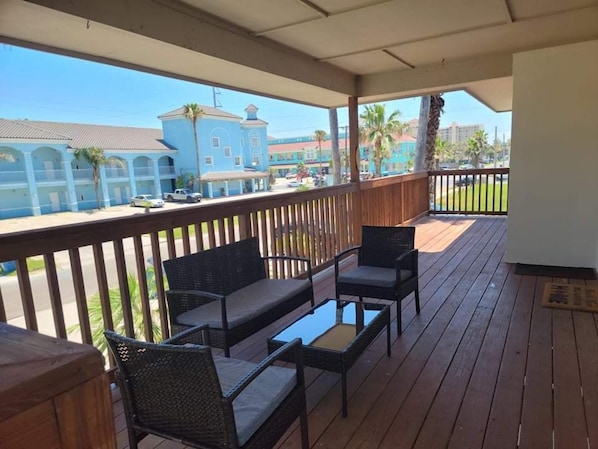 Relax on the covered deck with wicker chairs and a small table, taking in the views of the colonial-style buildings and street below.