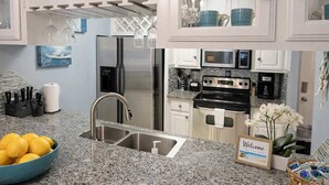 A modern kitchen with stainless steel appliances, granite countertops, and a built-in oven. - EZ Walk to Beach - Modern 2 Bedroom - Sleeps Many (South Padre Island)