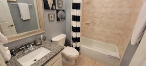 A bathroom with a granite countertop sink, a toilet, and a bathtub. - Mar y Sol II #1 (South Padre Island)