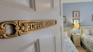 A room with a bed, bedside table, lamp, and wall art. - EZ Walk to Beach - Modern 2 Bedroom - Sleeps Many (South Padre Island)