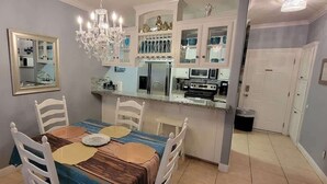 A dining area with a table, chairs, and a chandelier. - EZ Walk to Beach - Modern 2 Bedroom - Sleeps Many (South Padre Island)