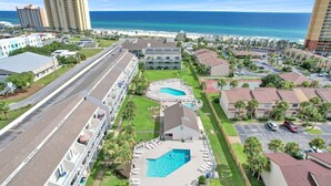 Ein Hotel mit mehreren Swimmingpools, Meerblick und einem Parkplatz.