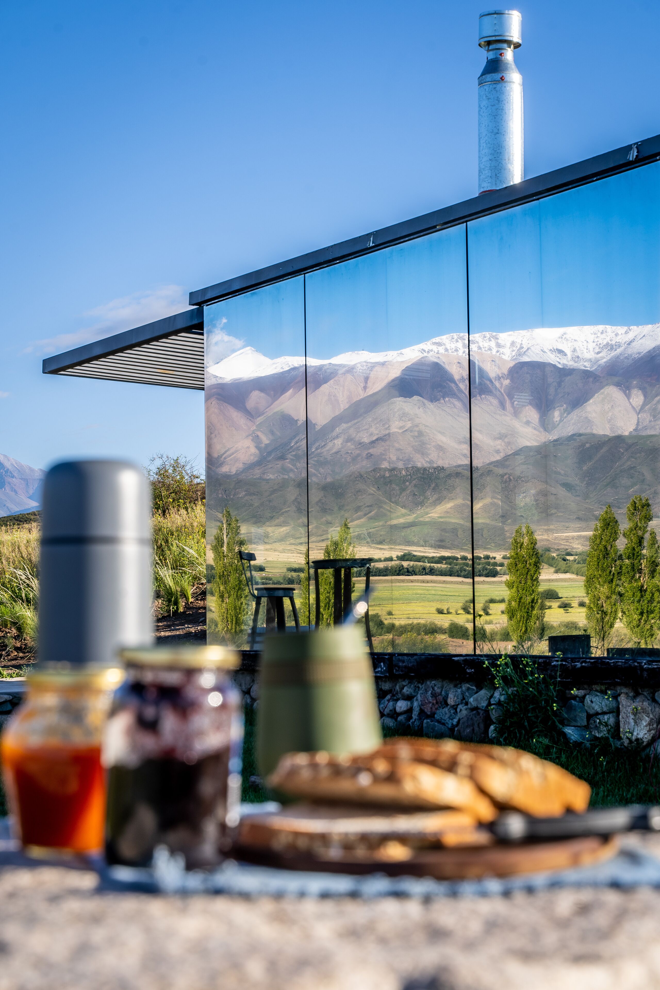 Una estructura moderna de vidrio con vistas a montañas nevadas.