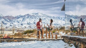 Un couple dînant en plein air, avec une vue sur les montagnes en arrière-plan.