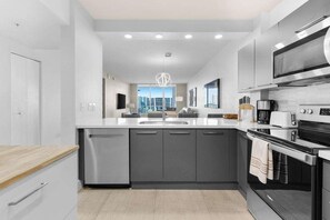 A modern kitchen with a central island, stainless steel appliances, and a view of the city.