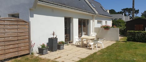 A house with a patio, a wooden fence, and potted plants.