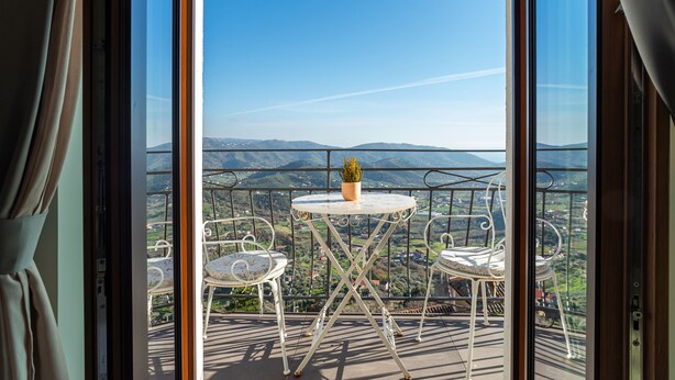 A balcony with a table and chairs, offering a view of a mountainous landscape. - De Gulia Charme and Relax (Castellabate)