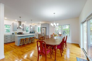 Une cuisine spacieuse avec un îlot central, des chaises en bois et une table à manger.