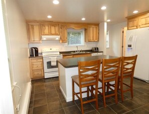 Enjoy cooking in this well-equipped kitchen with a central island, stove, oven, and dishwasher.