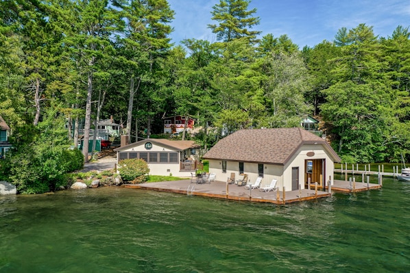 A lakeside cabin with a dock, surrounded by dense forest.