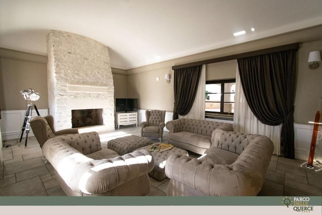 A living room with a stone fireplace, a sofa set, and a television.