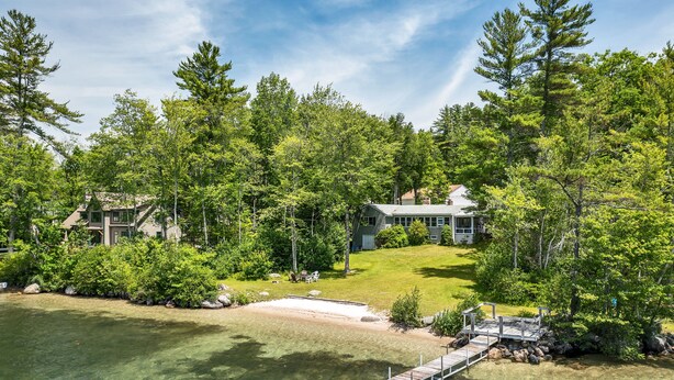 A lakeside property with a dock, a grassy yard, and two houses surrounded by dense trees. - Winnipesaukee Home PLUS Apartment For 10 Beach Dock Sunsets AUG 29TH SPECIAL (Moultonborough)