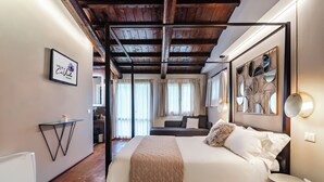 Un dormitorio con cama, mesita de noche, cuadro en la pared y techo con vigas a la vista.