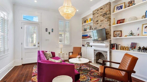 Una sala de estar con chimenea, televisión y estantería.