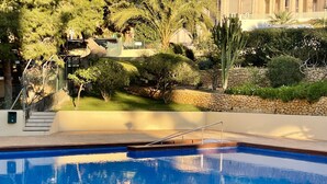Una piscina con borde de piedra y escalera metálica.