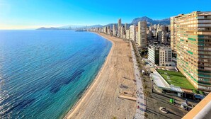 Un paisaje urbano costero con playa, edificios altos y cielo despejado.