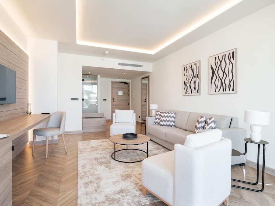 Ein modernes Wohnzimmer mit einem Flachbildfernseher, einer Akzentwand aus Holz, einem Sofa, einem Couchtisch und einem Teppich.