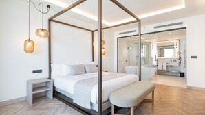 Un dormitorio moderno con cama con dosel, mesitas de noche, un banco y un espejo grande.
