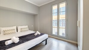 A modern bedroom with a large bed, a window with a view of buildings, and a ceiling light. - N&J - LE SALEYA - Old Town - Very close sea (Niza)
