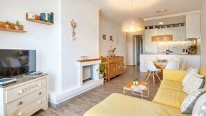 Una sala de estar moderna con sofá, televisor y chimenea.