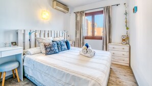 Un dormitorio con cama, mesita de noche y escritorio.