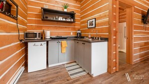 A compact kitchen with wooden paneling, a microwave, a coffee maker, and a small plant. - Paddlers Inn - Canoe Shop | Rustic | Quaint | Cozy (Canal Flats)