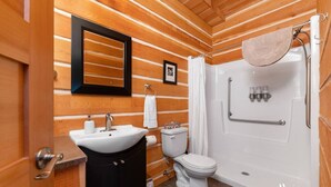 Une salle de bain avec un intérieur en bois, un lavabo, des toilettes et une baignoire avec un rideau de douche.