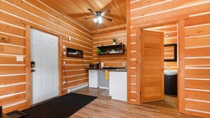 A log cabin interior with a kitchen, a bathroom, and a dining area. - Paddlers Inn - Canoe Shop | Rustic | Quaint | Cozy (Canal Flats)