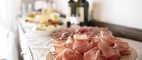 Una mesa con diversos alimentos y botellas de vino.