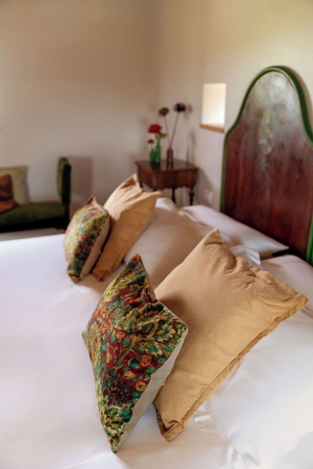 A neatly made bed with two decorative pillows and a plain pillow.