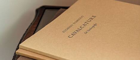 A stack of brown booklets on a wooden table.