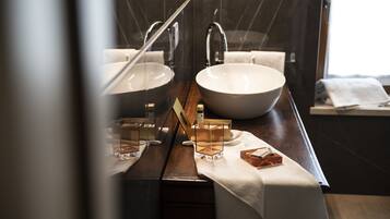 A bathroom with two sinks, a mirror, and a towel rack.