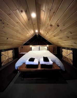 Cozy attic bedroom with a large bed and rustic charm.