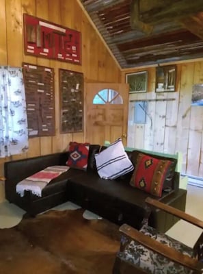 Relax in a warm and inviting space with a sofa, chair, and window offering a view.