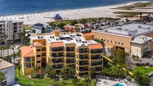 A hotel with multiple floors, a swimming pool, and a view of the beach and ocean. - Breathtaking Gulf View ~ 2min to Beach ~ Pool ~ Pkg (Treasure Island)