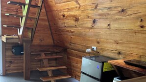 Une cuisine de taille réduite, avec un intérieur en bois, un réfrigérateur encastré et un évier.