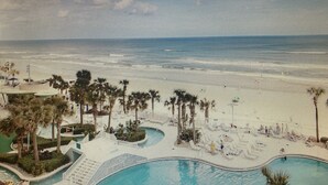 Ein Resort mit Pool, Strand und Palmen.