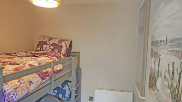 A bunk bed room with a mural of a beach scene on the wall.