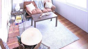 A cozy room with a wooden ceiling, a sofa, a coffee table, and a window. - Rustic cottage-style condo within walking distance to downtown Homewood (Homewood)