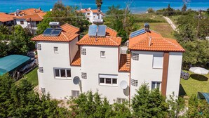 En bostadsbyggnad med solpaneler, satellitantenner och utsikt över havet.