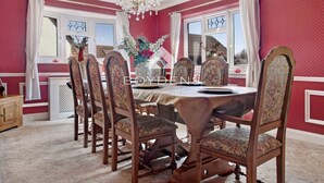 A dining room with a large table, six chairs, a chandelier, and a window with curtains. - Wix, with its rolling countryside and reputation as a peaceful village, perfect for a rural stay (Manningtree)