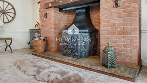 A brick fireplace with a decorative metal grate, a basket, and a lantern on the mantel. - Wix, with its rolling countryside and reputation as a peaceful village, perfect for a rural stay (Manningtree)