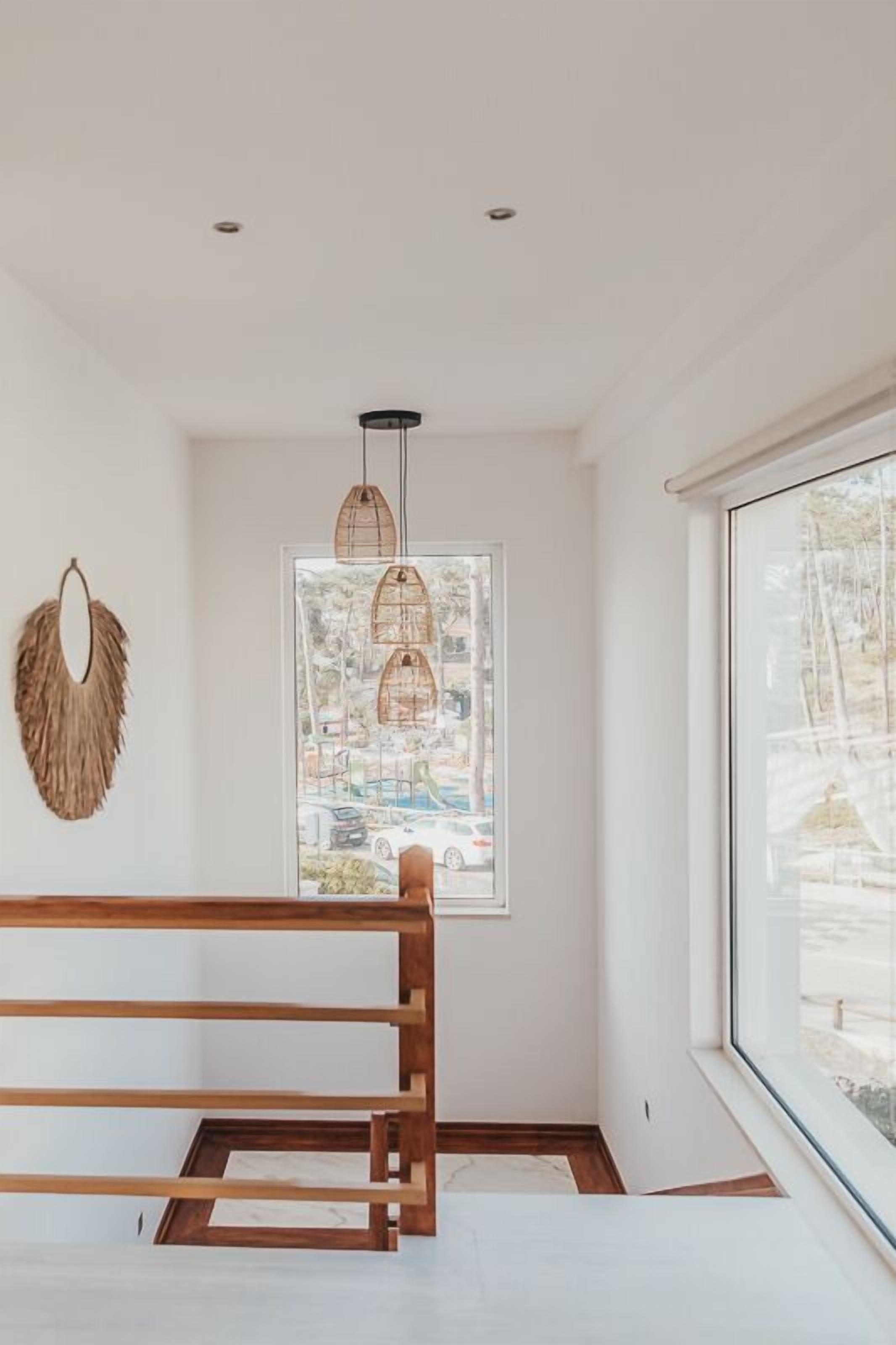 Una habitación moderna con un banco de madera, un ventanal grande y una obra de arte colgada en la pared.