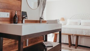 Ein modernes Badezimmer mit einem Holzkosmetikschrank, einem Spiegel und einem Nachttisch mit Lampe.