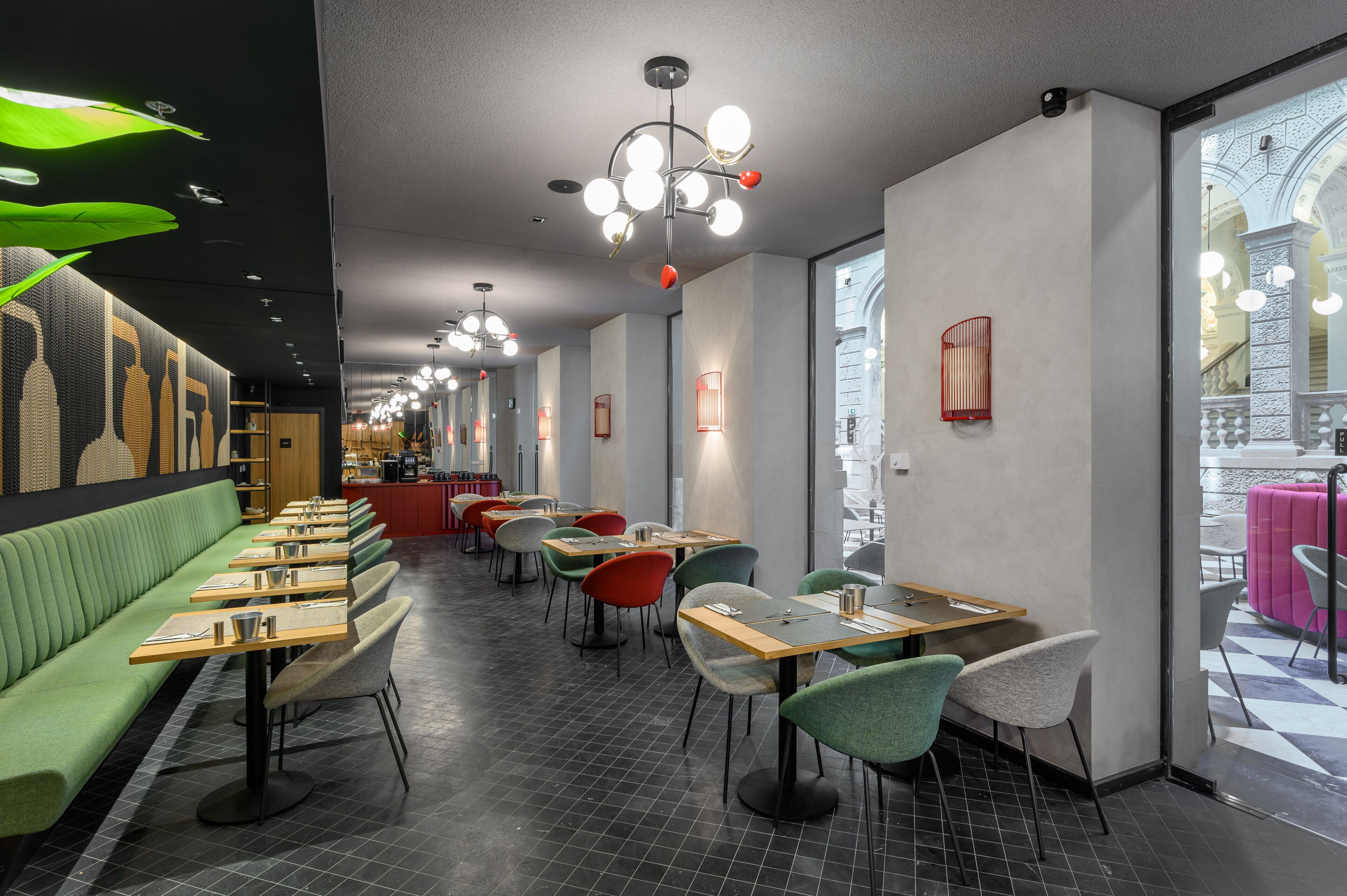 Um interior de restaurante moderno com várias áreas de estar, incluindo cabines e mesas, e uma variedade de cadeiras.