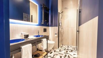 Un bagno moderno con due lavandini, un water e una cabina doccia in vetro.
