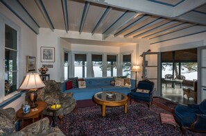 Relax in a cozy living room with a comfortable seating area, round coffee table, and large window offering a view of the outdoors.