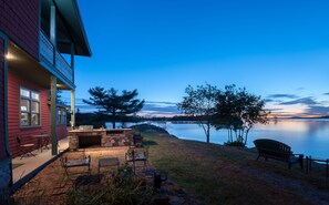 Enjoy serene lakeside views from the balcony with outdoor seating and a cozy fireplace.