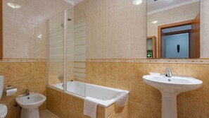 Ein Badezimmer mit Duschkabine, Standwaschbecken und Toilette.