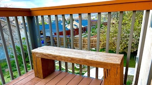 Un banco de madera en una terraza de madera con barandilla.